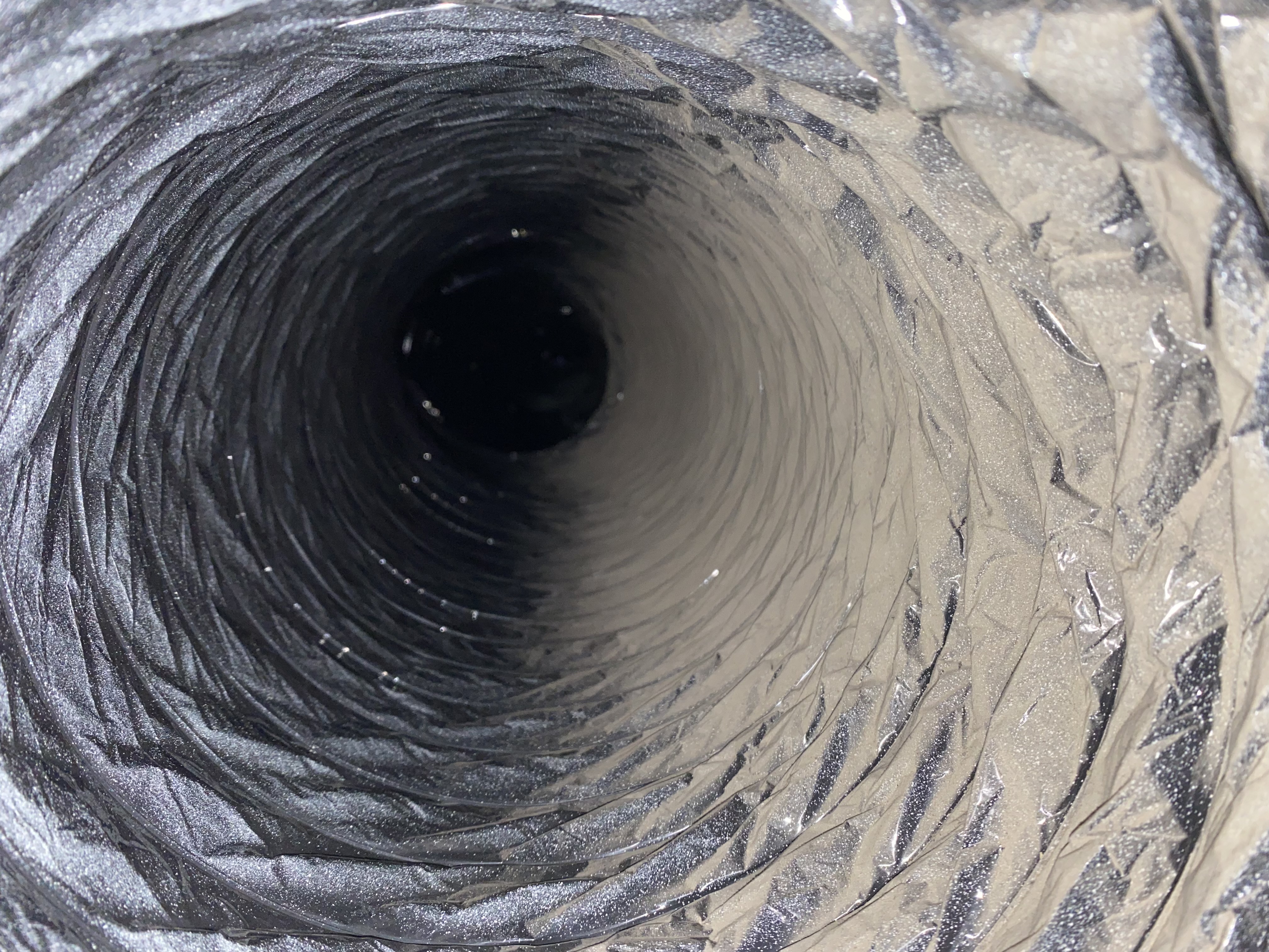 Inside view of a dirty flexible air duct before cleaning